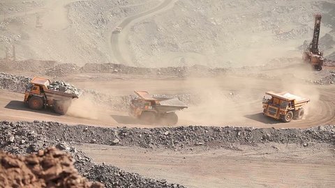 Heavy mining truck on the iron ore opencast mining quarry, three trucks driven by iron ore in career, industrial exterior, ore mining quarry, sunny day, summer, mining of iron 