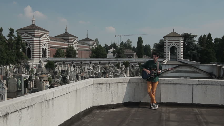 ? young man playing the guitar on the roof