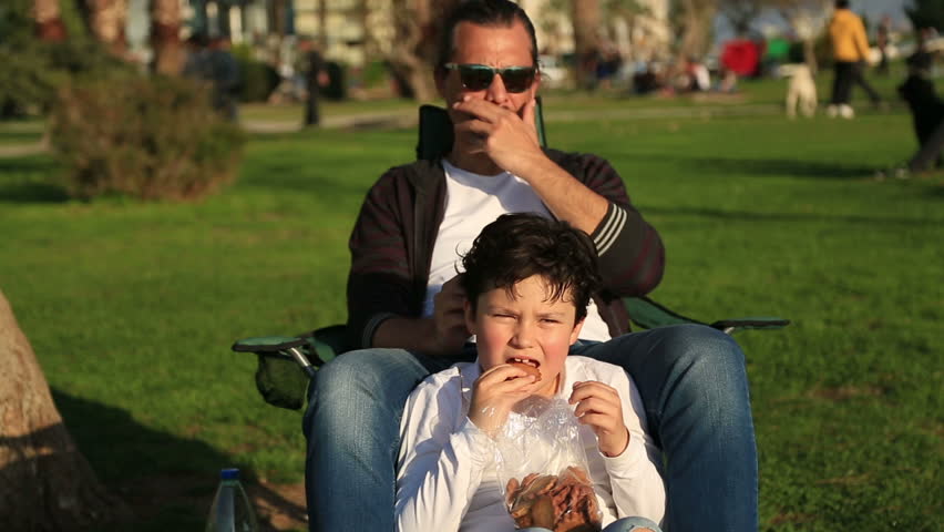 Happy family having fun ,Father and son sitting and relaxing in the park