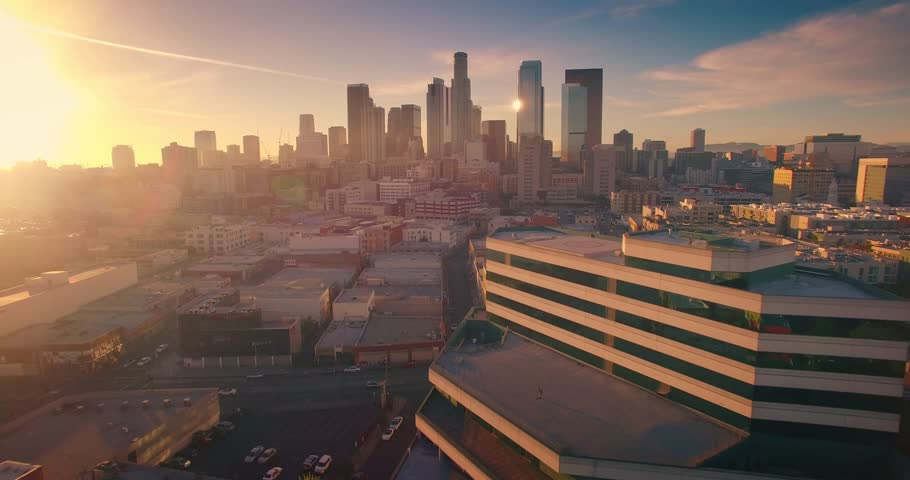 Aerial view of city of Los Angeles downtown skyline at sunset. Camera flying forward. 4K UHD.