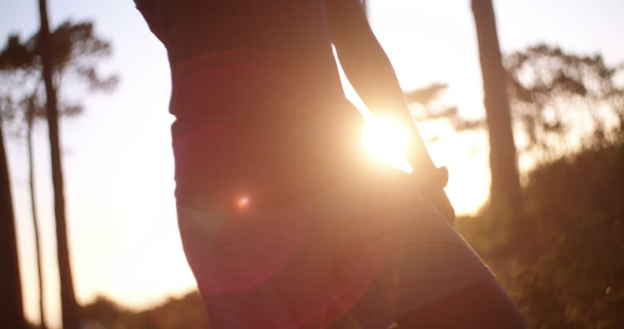 Angle shot of african-american decent cross-country athlete drinking water after a long exercise routine in the woods