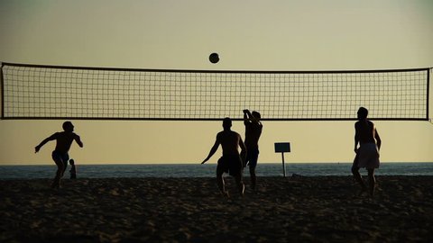 silhouette of volleyball players on the beach at sunset