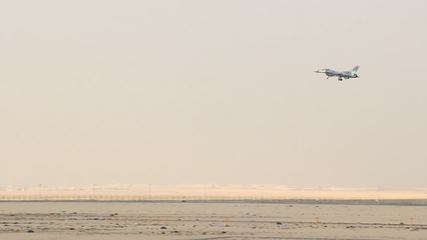 Small batteplane fly down to runway, landing at Al Maktoum airport. Dubai Airshow, military aviation show in action. General Dynamics F-16 Fighting Falcon single-engine multirole fighter aircraft.