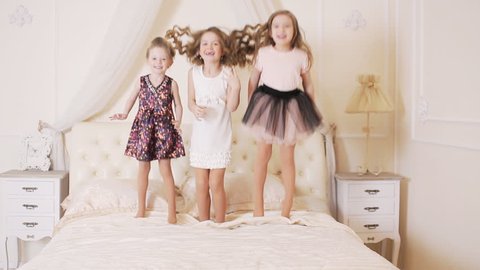 little girls jumping on the bed