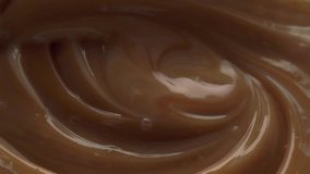 Mixing dense chocolate cream with egg whisk. Macro video