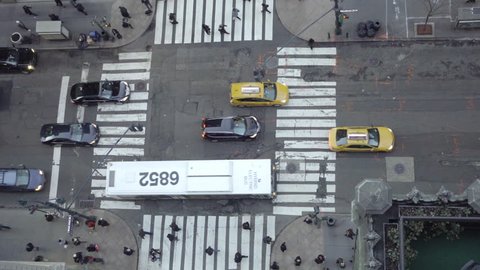 overhead downward view of intersection in Midtown Manhattan with cars, taxis, bus and people from above in 4K NYC