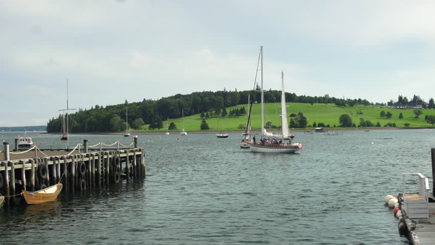 A schooner, filled with tourists, prepares to set sail by hoisting it