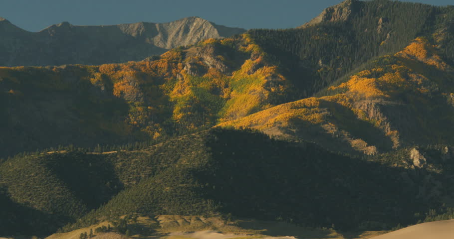 4K Pan Sangre De Christo Mountains in autumn fall To barren desert dunefield Great Sand Dunes National Park Colorado