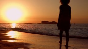 Video of woman walking on beach during sunset