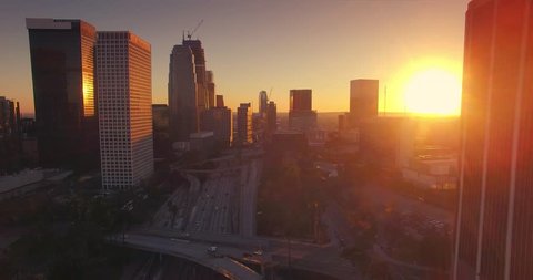 Aerial view of downtown Los Angeles skyline at sunset. Camera flying forward. 4K UHD.