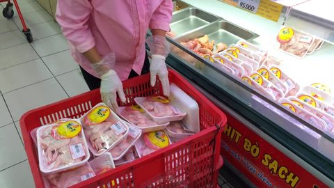 VUNG TAU, VIETNAM - FEBRUARY 18, 2016: An unidentified shop worker lays chicken meat out in a showcase at a Lotte Mart supermarket.