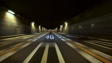 Driver POV entry to the Tokyo Bay Underpath on the Bayshore Freeway. Yellow and white lane stripes and random illumination through the tunnel.