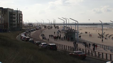 SCHEVENINGEN, THE NETHERLANDS - FEBRUARY 2016: People enjoy a sunny winter day at the North Sea boulevard - wide shot.