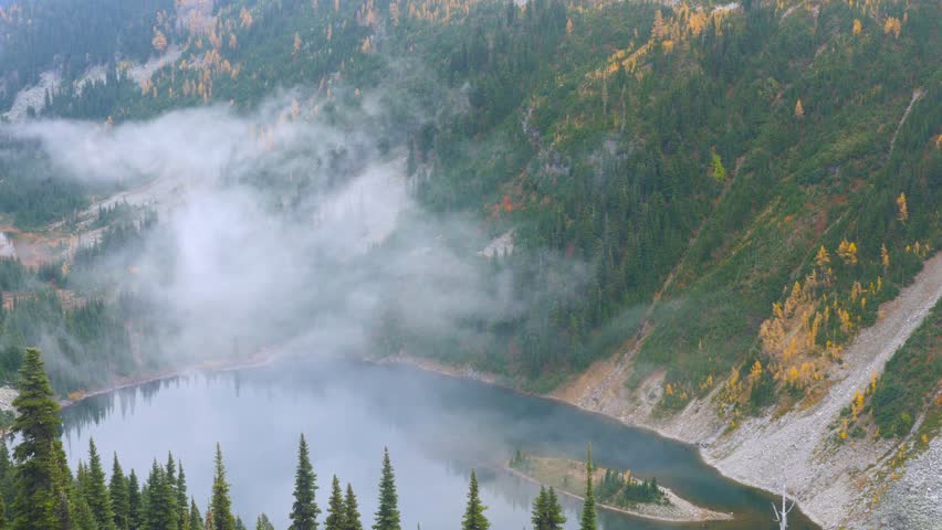 A small island in the middle of a mountain lake. Transparent lake. Fir forest on rocky mountainside.North Cascades National Park. Washington state. Landscape video.4K, 3840*2160, high bit rate, UHD