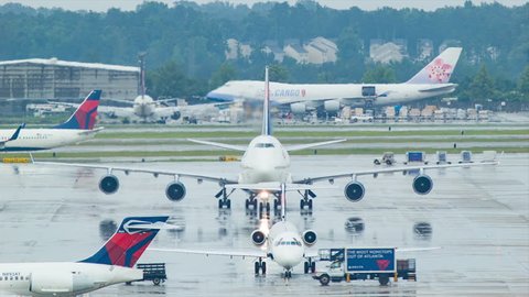 ATLANTA GA - 2015: Atlanta ATL Airport Delta Airlines Airplane Action with Boeing 747 and other Regional Jet Airplanes on Wet Platform