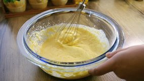 Closeup of mixing flour with already beaten up eggs and sugar using an hand mixer 