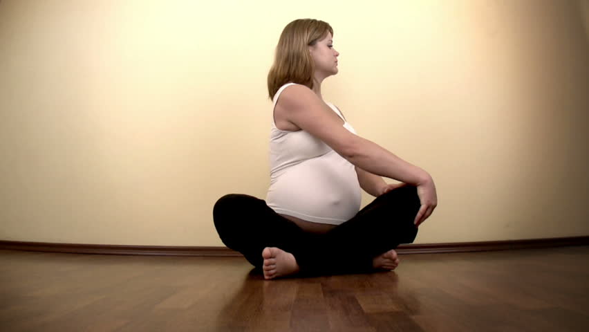 Pregnant woman exercising on the floor