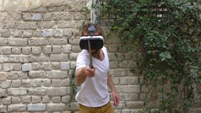 A man plays virtual augmented reality game using head mounted display and a motion sensing sword