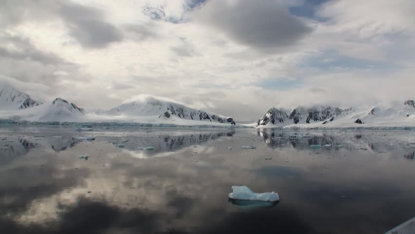 Moving Ice Floes and Ice Sheets in the calm Antarctic Sea, Reflection of Antarctica Mountain in water surface. Amazing beautiful views of Nature and landscape of snow, ice and white of Antarctic.