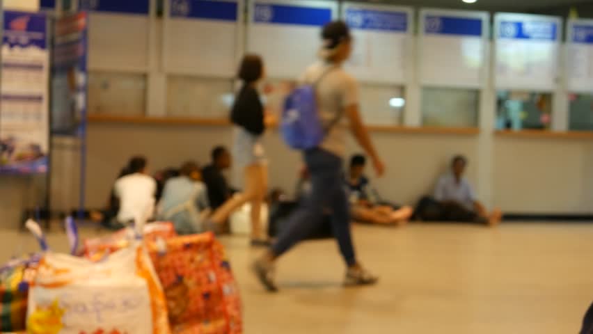 View of Public bus terminal of Bangkok called Mo chit Mai. People wait for buses in the terminal. Some walk to their platforms where buses wait for passengers. 