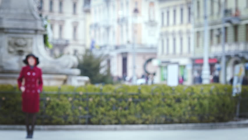 Young beautiful lady walking to camera. Model looking at camera and posing in focus. Woman wearing stylish clothes and black wide-brimmed hat.