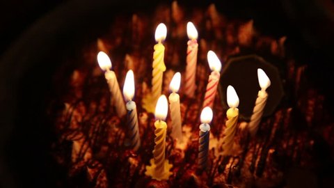 Happy Birthday cake with burning spiral candles which are then extinguished