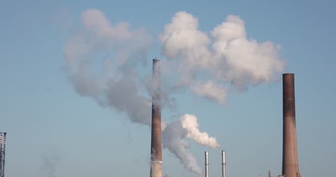 Climate Change video: chimney of a oil industry on a sunny winter day