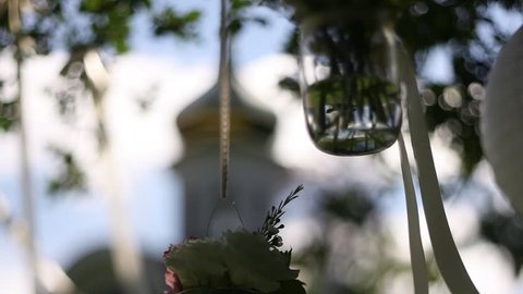Transparent Small Vase of Flowers Swaying in the Wind, Against the Backdrop of the Dome of the Church With Gold Cross, Wedding Decoration, Holiday Decoration in the Outdoors Stock Video