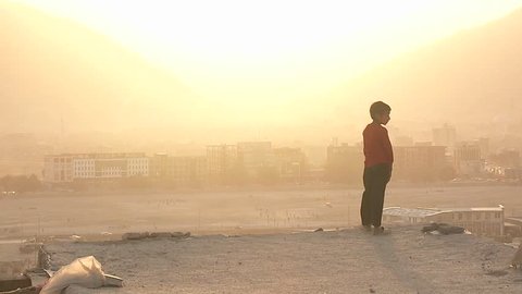 KABUL, AFGHANISTAN - CIRCA 2009: A boy looks out during a dust storm circa 2009 in Kabul, Afghanistan. Afghanistan is an impoverished and least developed country, one of the world's poorest.