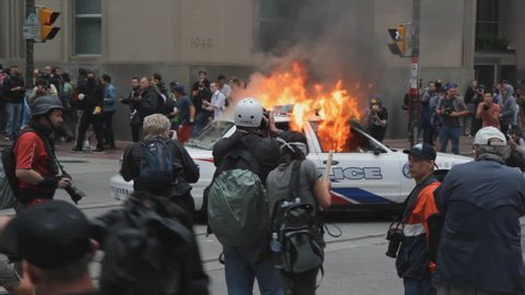 TORONTO, ONTARIO – JUNE 26th: Burning police car at the corner of Bay and King St on June 26th, 2010, Toronto, Ontario, Canada. Police and protesters clash at the G20 summit being held in Toronto.