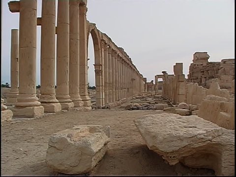 PALMYRA, SYRIA - CIRCA 2004: Side view of the Great Colonnade at Palmyra with archaeological debris in the foreground. The colonnade originally linked the Temple of Bel to the Funerary Temple.