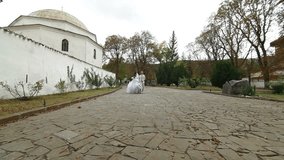 Crimean Tatar newlyweds walking through the park Bakhchisarai Palace (Hansaray, Khan's Palace) Bakhchisaray, Crimea, Ukraine. 