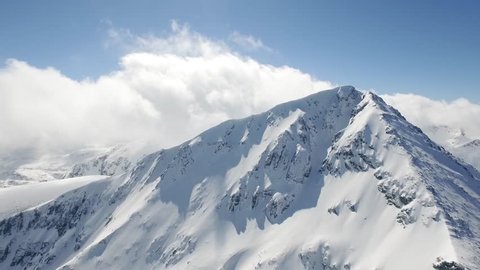 Aerial Flight Over Around Snowy Peak Beautiful Blue Sky Clouds Epic Adventure Journey Concept UHD 4K