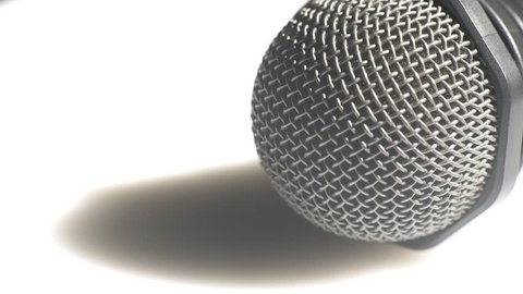 Macro view of a head of a classic handheld microphone steel grid turning left
