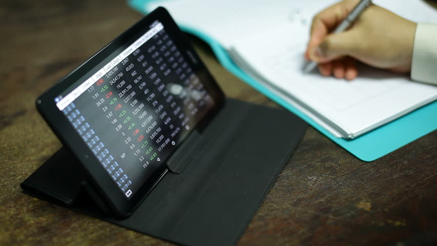 Touchscreen stock exchange on tablet with writing on document | Shutterstock HD Video #15083260