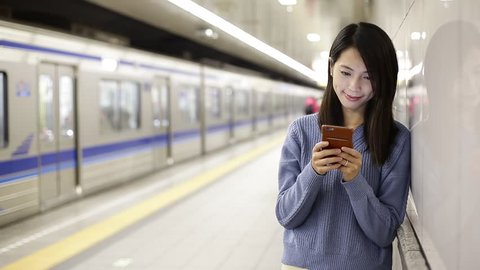 Woman use of smartphone at subway station