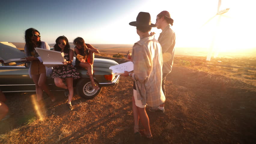 Group of multi-ethnic young adult women eating pizza in summer at sunset