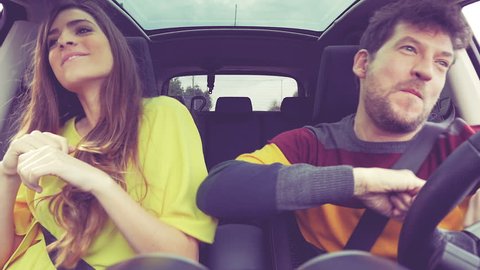Beautiful woman with long hair and happy man dancing driving car happy 