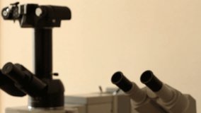 Old blurred microscopes diagonal panning. Focus on the modern microscope luminous objectives in the end of panning. Another equipment is out of focus.  Moving on the right an down.