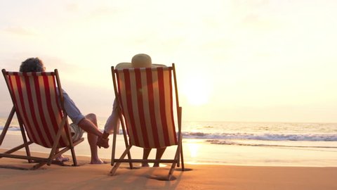Older Couple in Love on Vacation. Retirement Couple Enjoying Sunset on Beautiful Tropical Beach. SLOW MOTION
