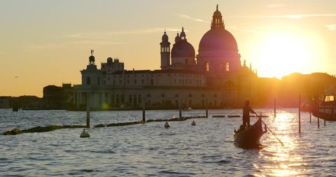 Gondola with Santa Maria Della Salute at sunset, Grand canal. Venice, Italy.