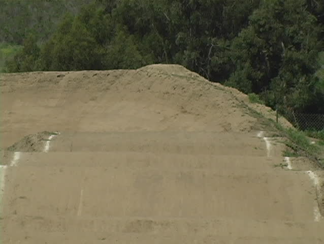 A view of BMX racers coming straight at the camera before turning right.