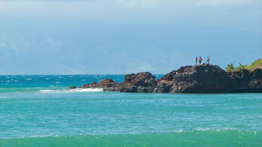 People Standing on Top of Black Rock at Kaanapali Beach Maui Hawaii with Tropical Blue Pacific Ocean Water Underneath