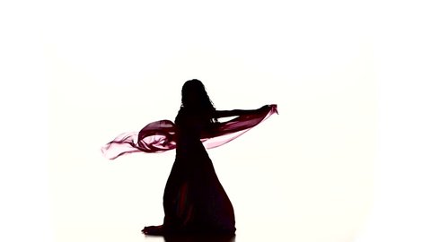 Pretty young girl dancing belly dance with colored shawl, on white, slow motion