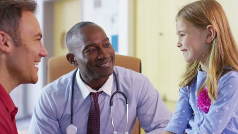 4K Friendly doctor talking to father and child patient in his office, videoclip de stoc