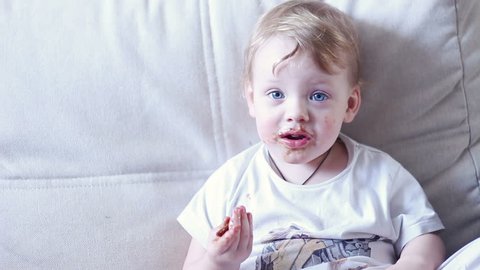 Little Boy Eating Chocolate And Smeared Mouth