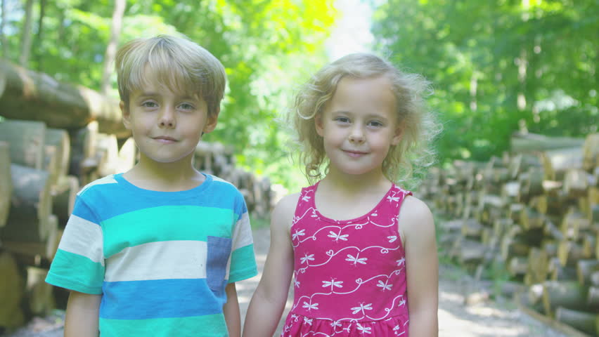 4K Happy little boy & girl in the woods share a hug