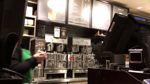 Coquitlam, BC, Canada - March 07, 2016 : Customer buying coffee and paying by gift card at Starbucks with 4k resolution.