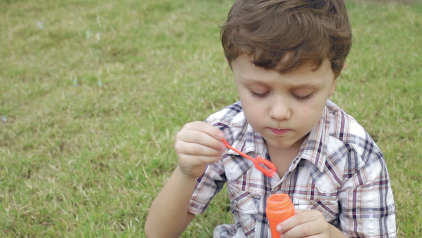 Portrait happy little boy sitting in the park