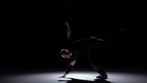 Cool breakdance style dancer continue dance, on black, shadow, slow motion